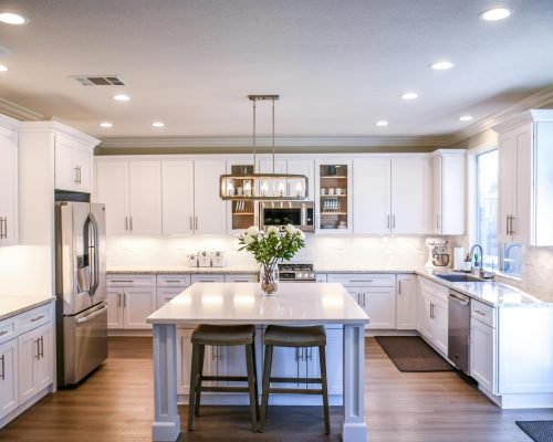 Spacious and elegant kitchen featuring white cabinetry, island, and stainless steel appliances.