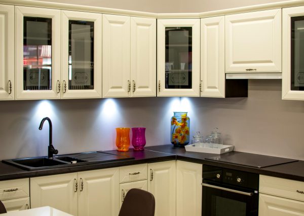 A stylish modern kitchen with white cabinets and colorful decor pieces.